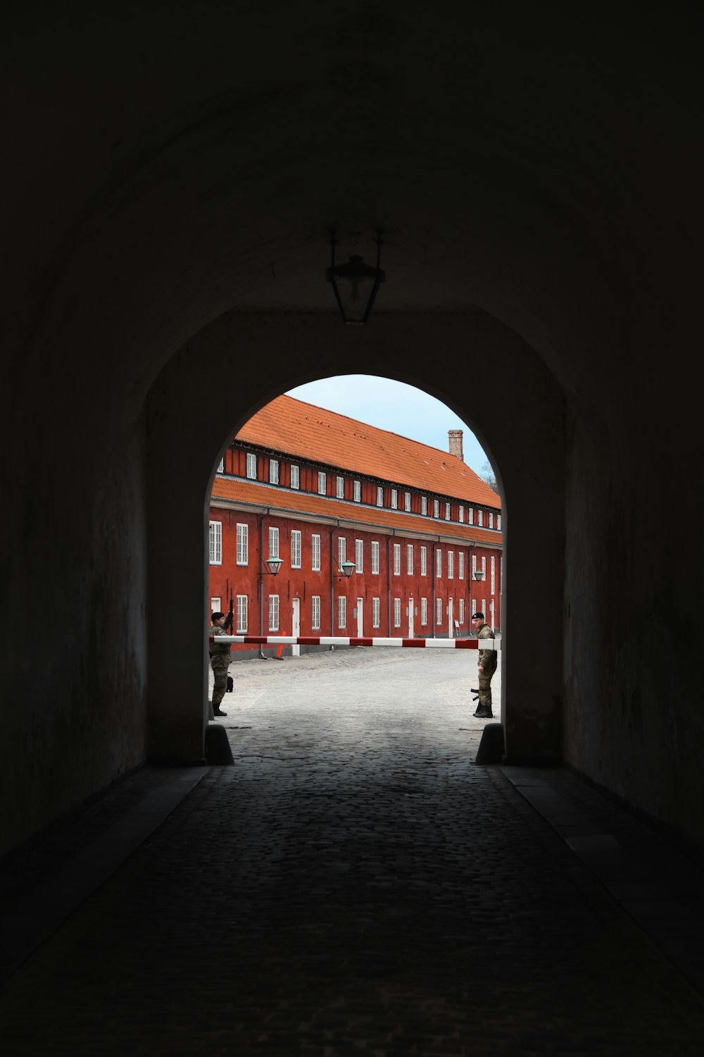 a dark tunnel leading to a red building