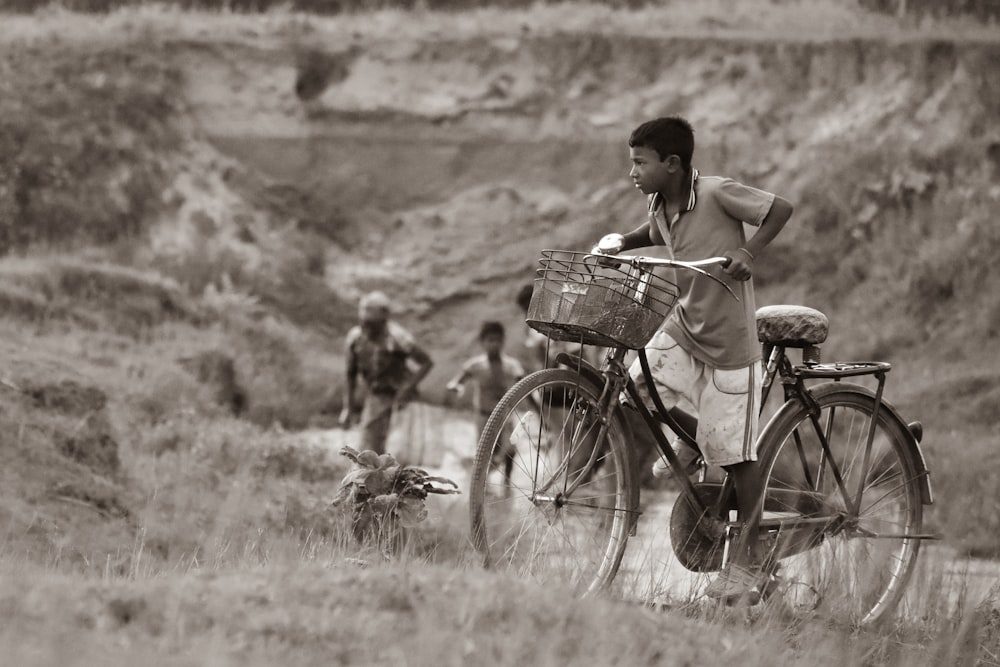 a man riding a bike down a dirt road