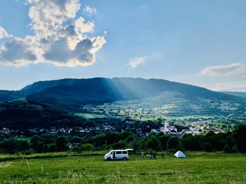 a van parked in a field with a mountain in the background