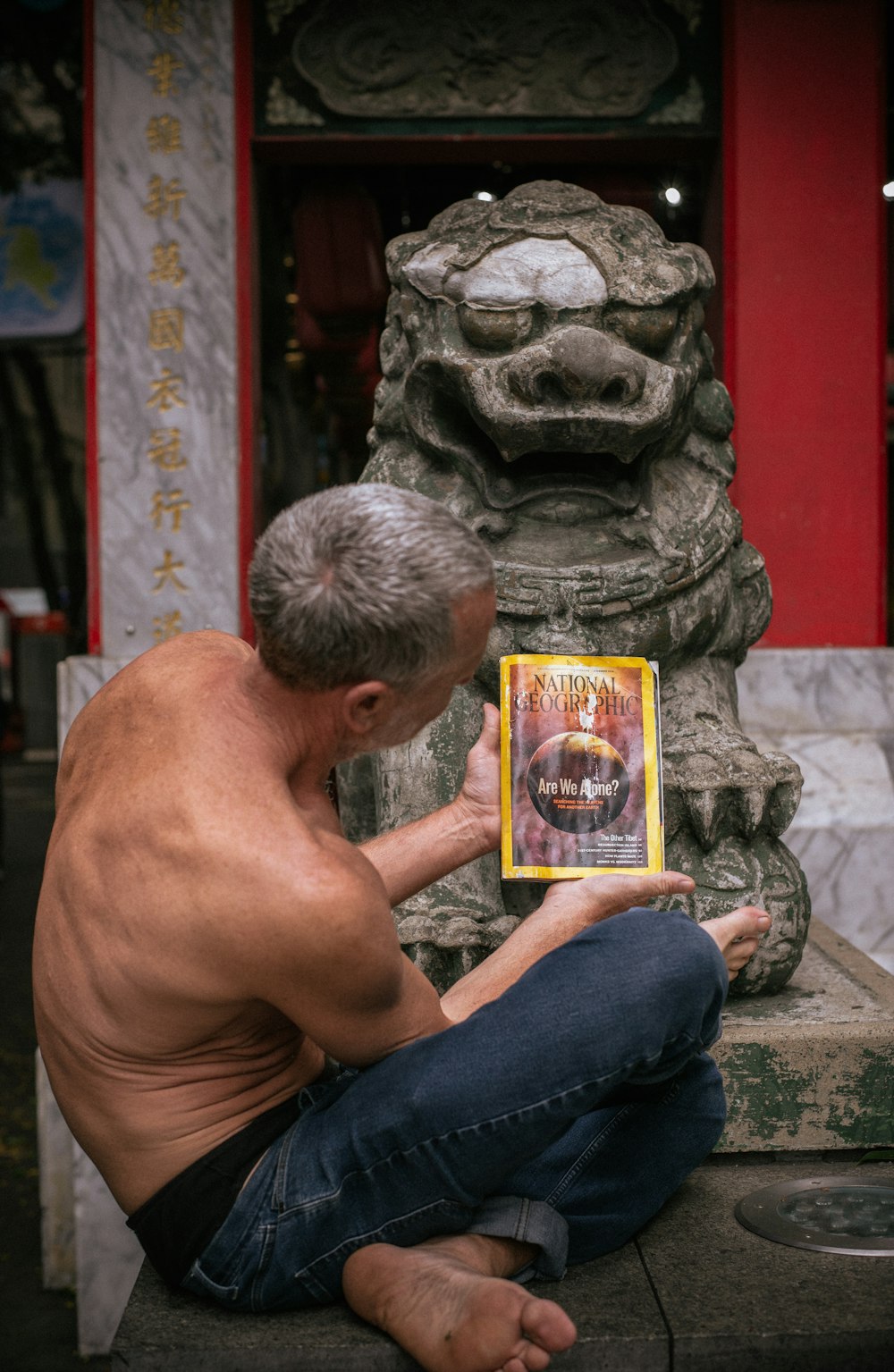 a man sitting on the ground holding a book