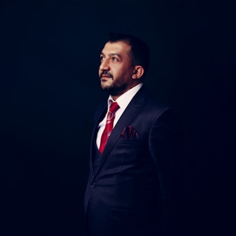 a man in a suit and red tie