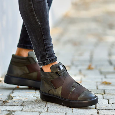 Model walking along a city sidewalk wearing reverd’s clean-cut trousers and sneakers.