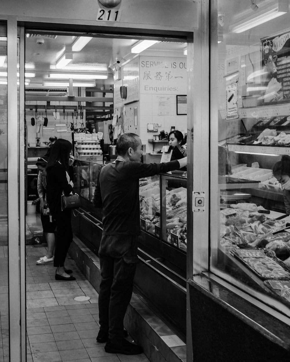 a black and white photo of people shopping in a store