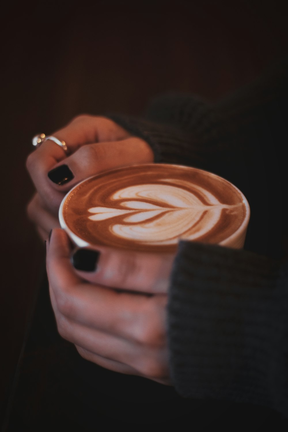 a close up of a person holding a cup of coffee