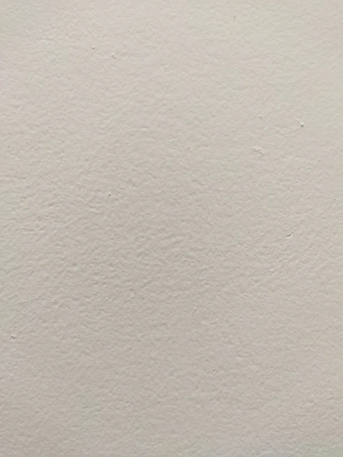 Close-up of a smooth plastered wall with a subtle texture under soft lighting