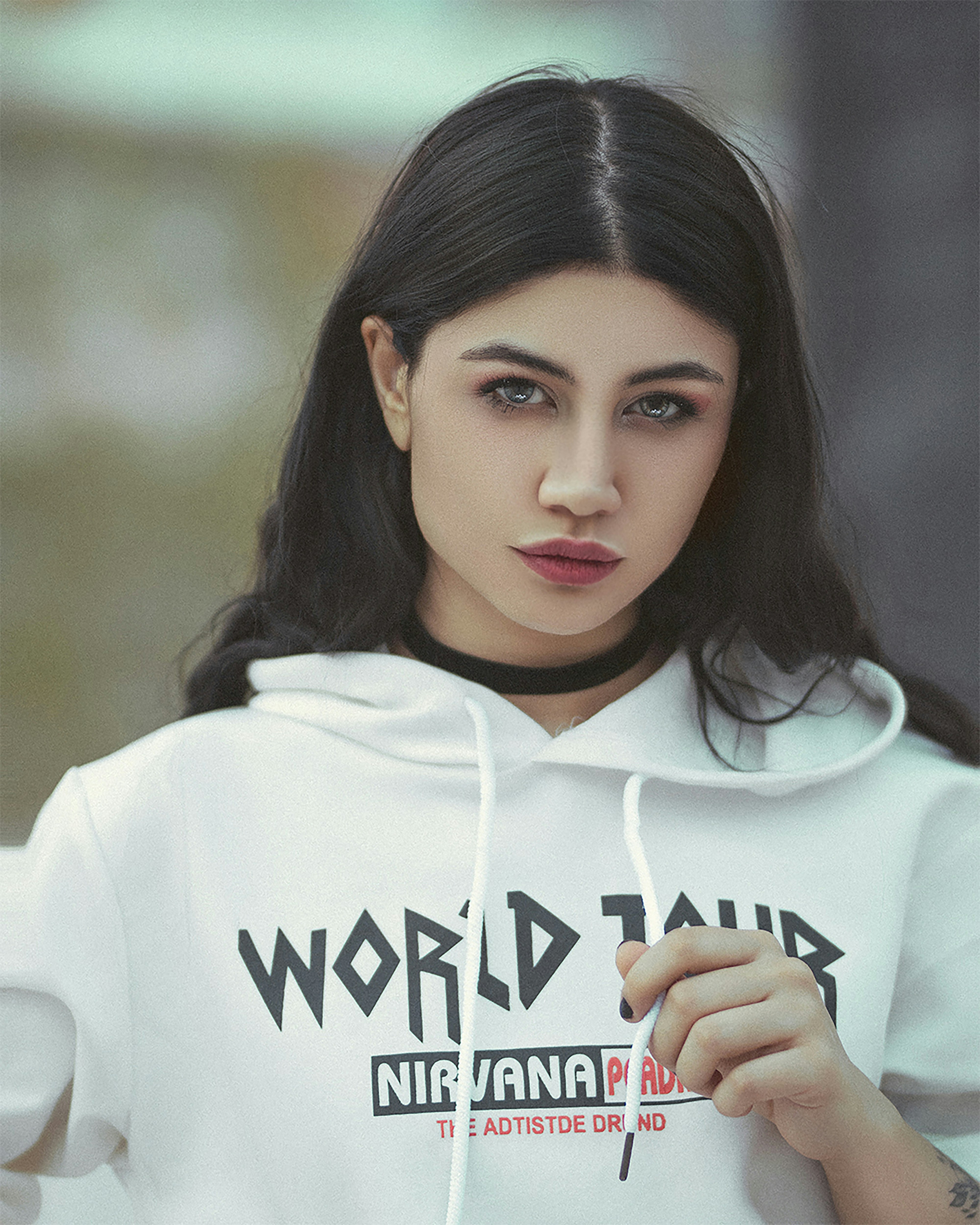 a woman with black hair wearing a white hoodie