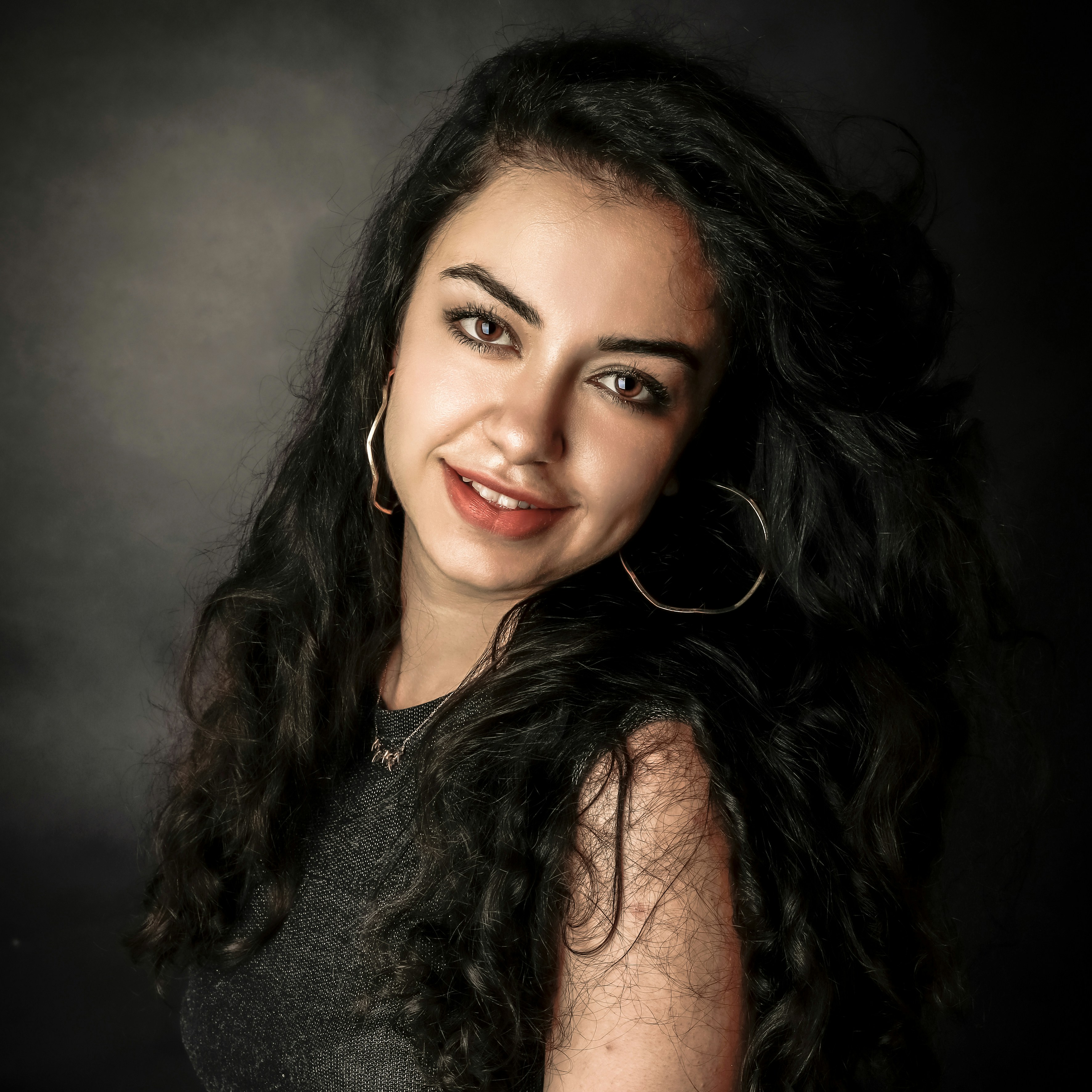 Rebecca M., a smiling woman with long black hair