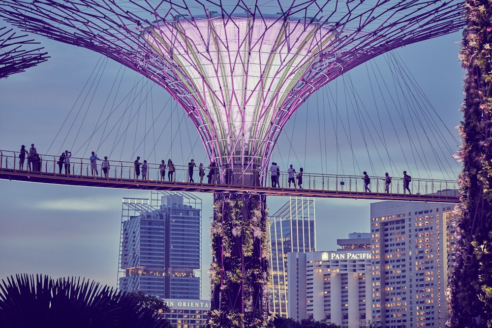 a group of people walking across a bridge