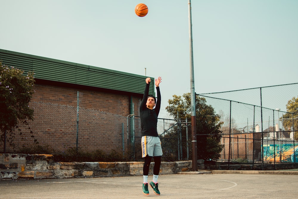 a man in a black shirt is playing basketball