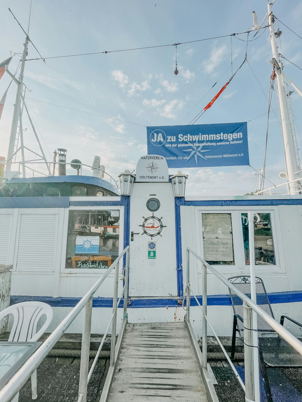 a white and blue boat docked at a dock