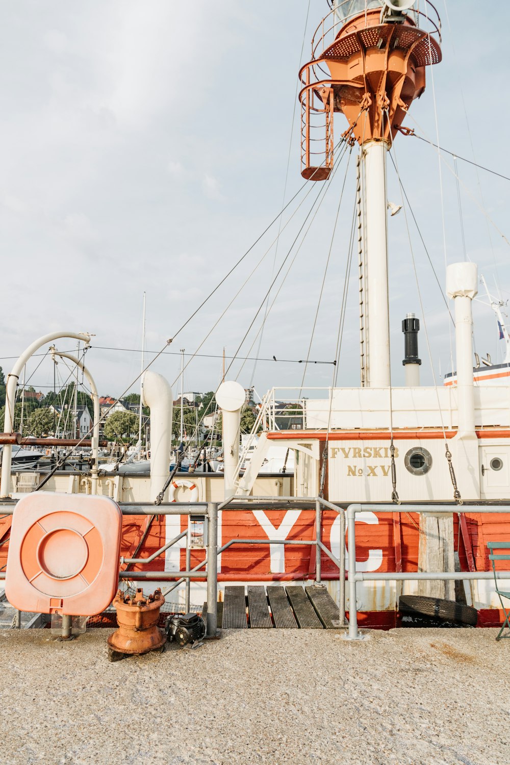 an orange and white boat docked at a pier