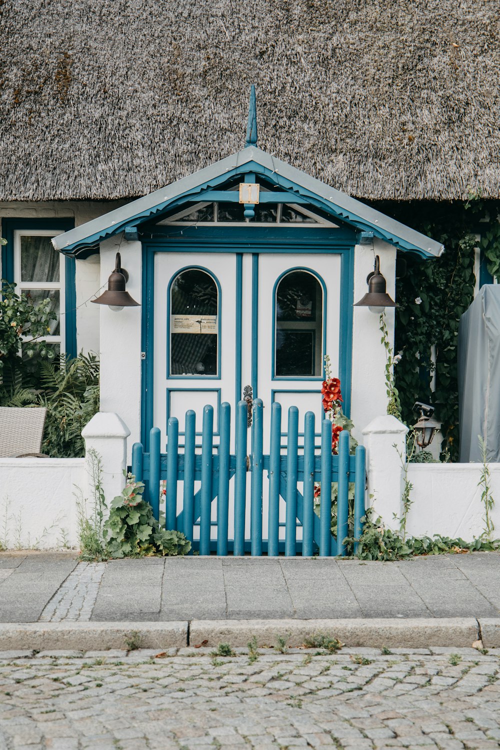 a blue and white house with a blue picket fence