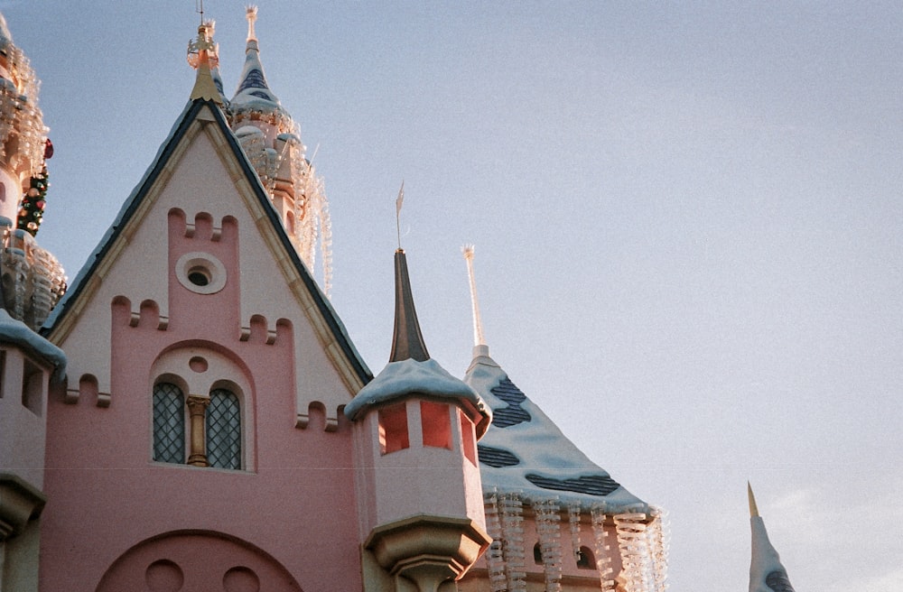 a pink castle with a clock on the front of it