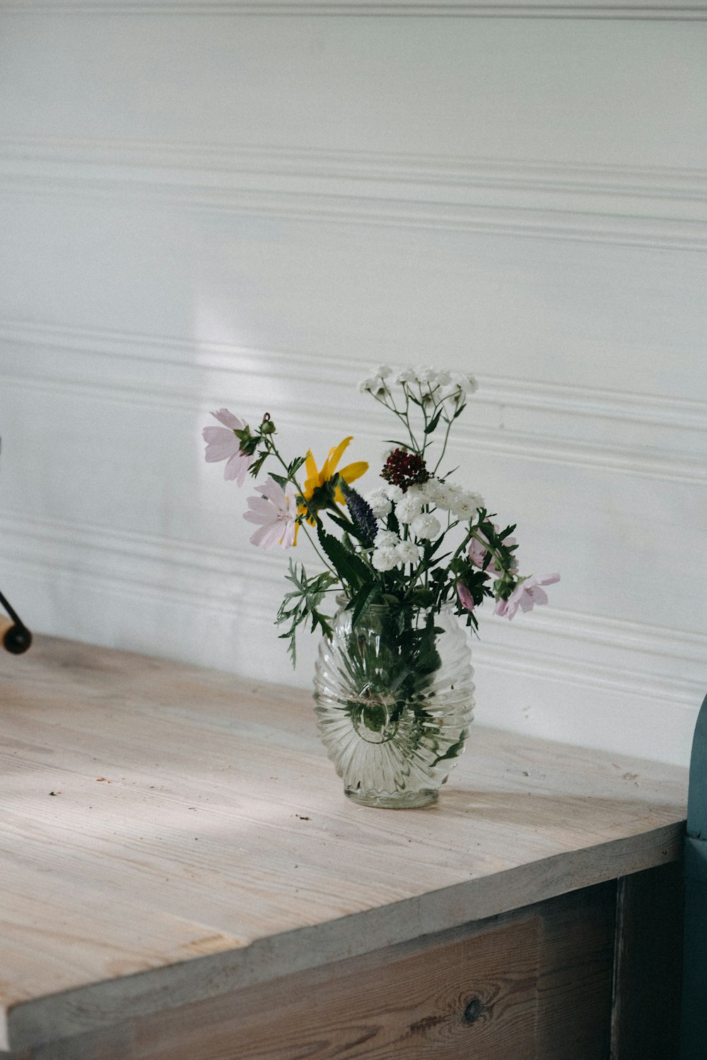 a vase of flowers sitting on a wooden table