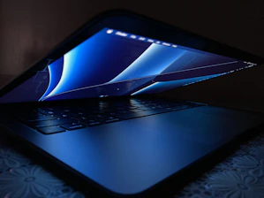 A stylish laptop display featuring blue and gray color themes under soft lighting.