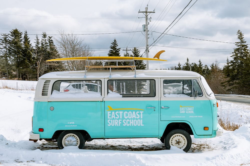 a blue and white van with a surfboard on top of it