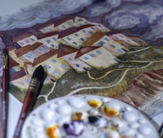 a table with a plate of food and paint brushes