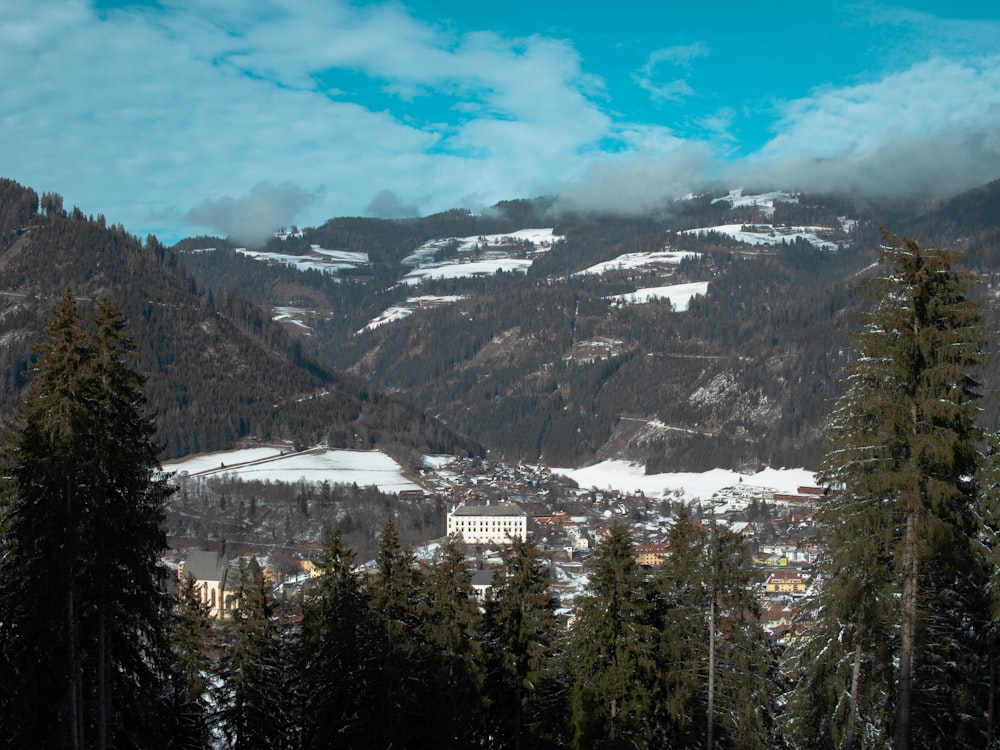 a view of a town in the mountains covered in snow