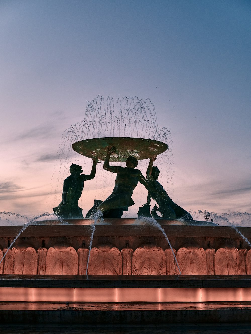 a couple of people sitting on top of a fountain