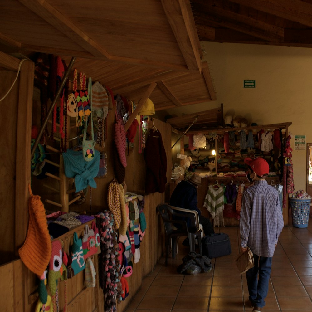 a man walking through a store filled with lots of items