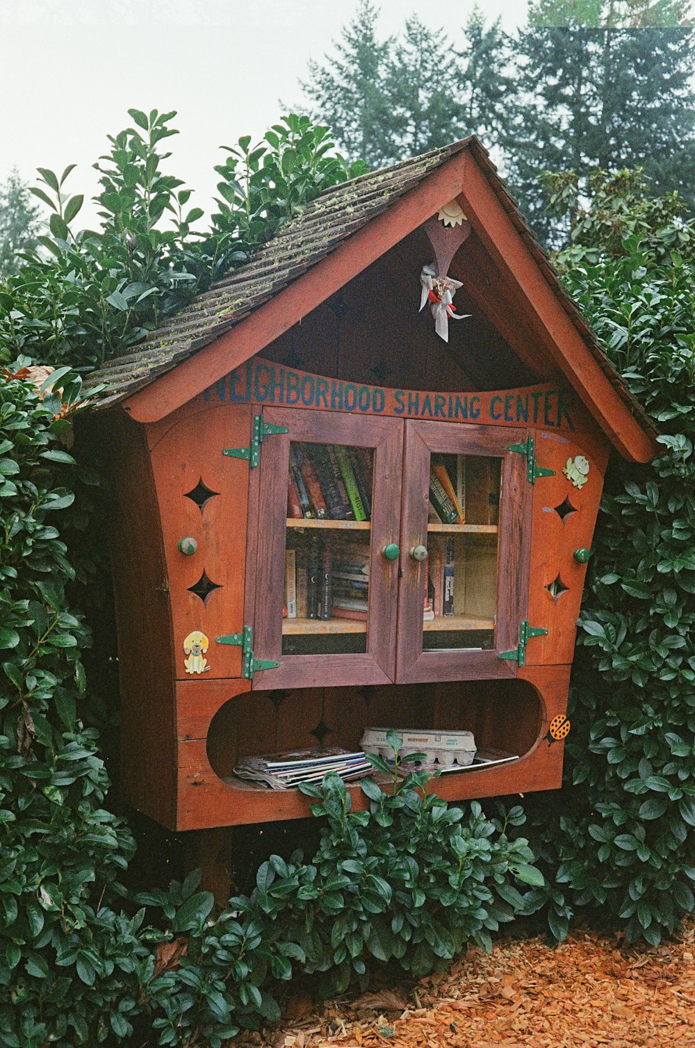 a small wooden house with a book shelf inside of it