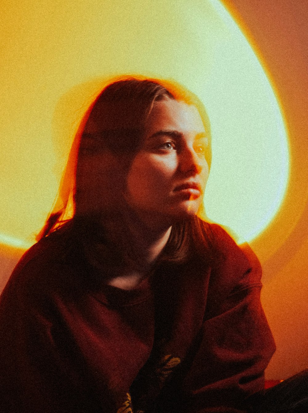 a woman sitting in front of a yellow light