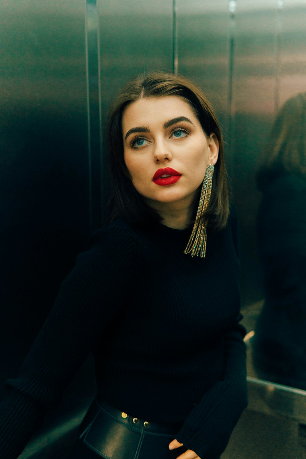 a woman standing in a elevator with a red lipstick