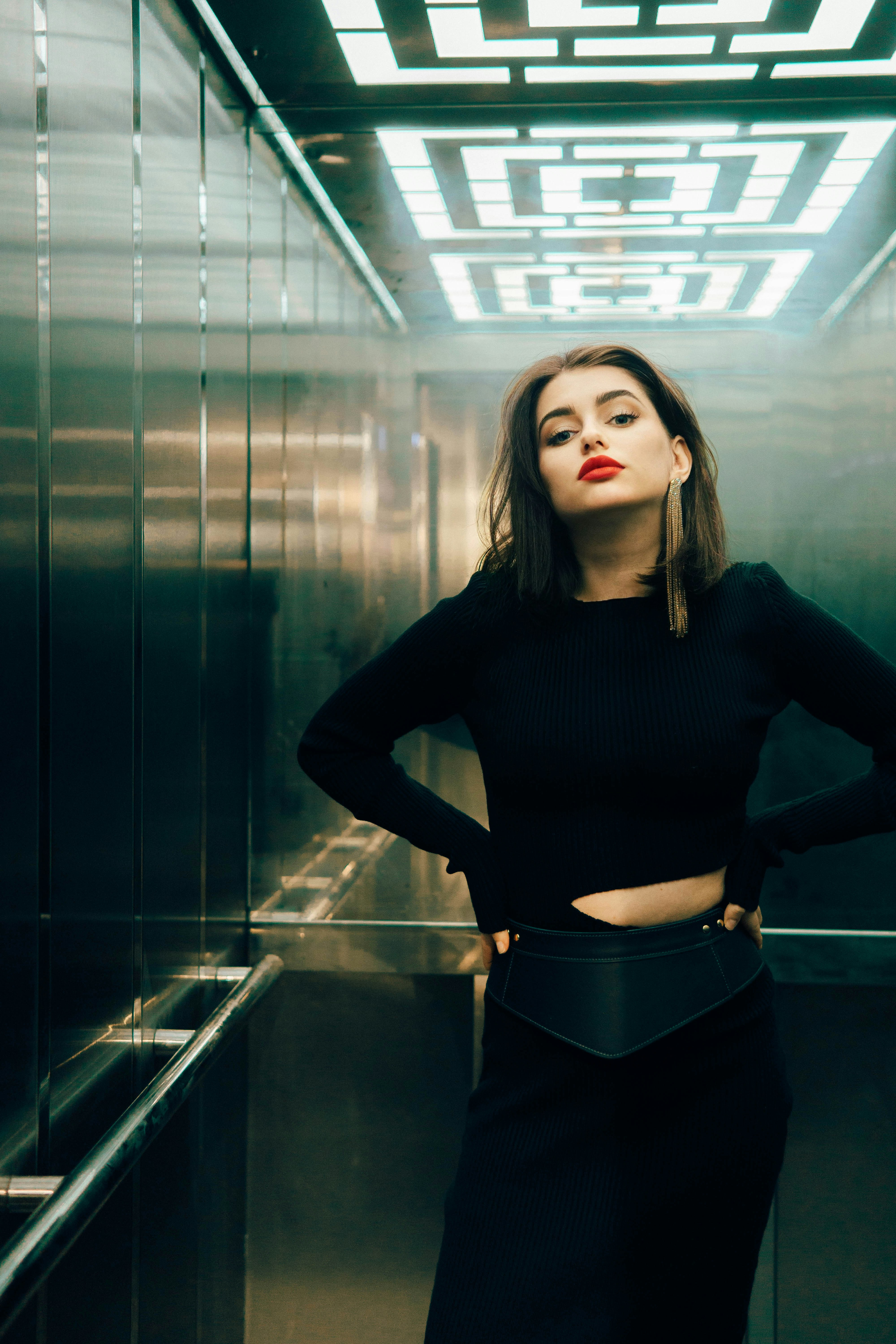 a woman standing in a hallway with her hands on her hips