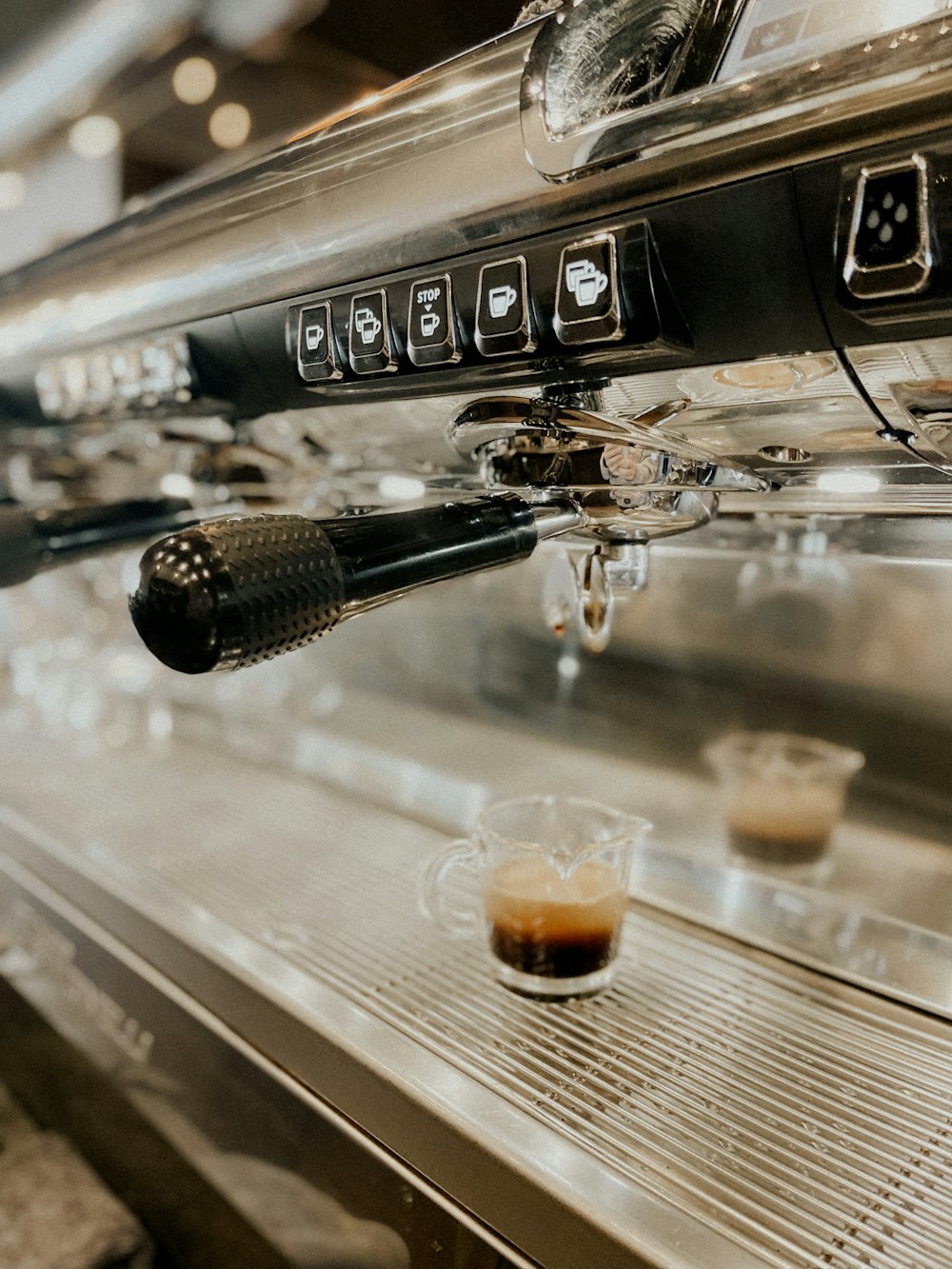 a espresso machine with a cup of coffee next to it