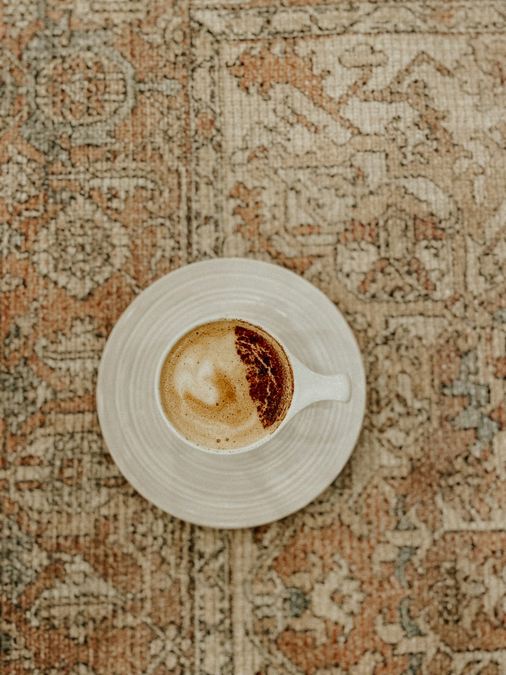 a cup of coffee sitting on top of a white saucer