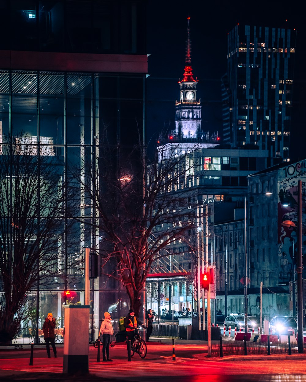 Eine Stadtstraße bei Nacht mit einem Glockenturm im Hintergrund