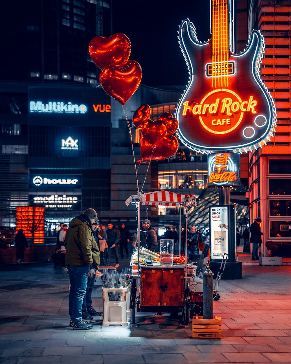 a man standing next to a guitar shaped sign