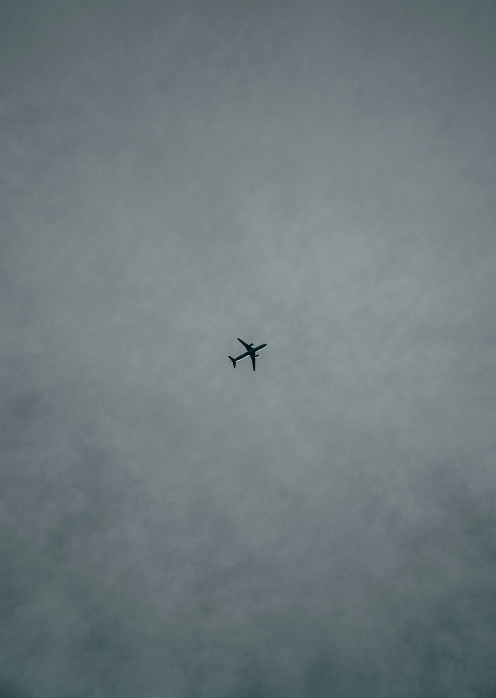 an airplane flying in the sky on a cloudy day