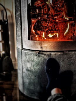 A cozy living room scene with someone wearing warm slippers by the fireplace.