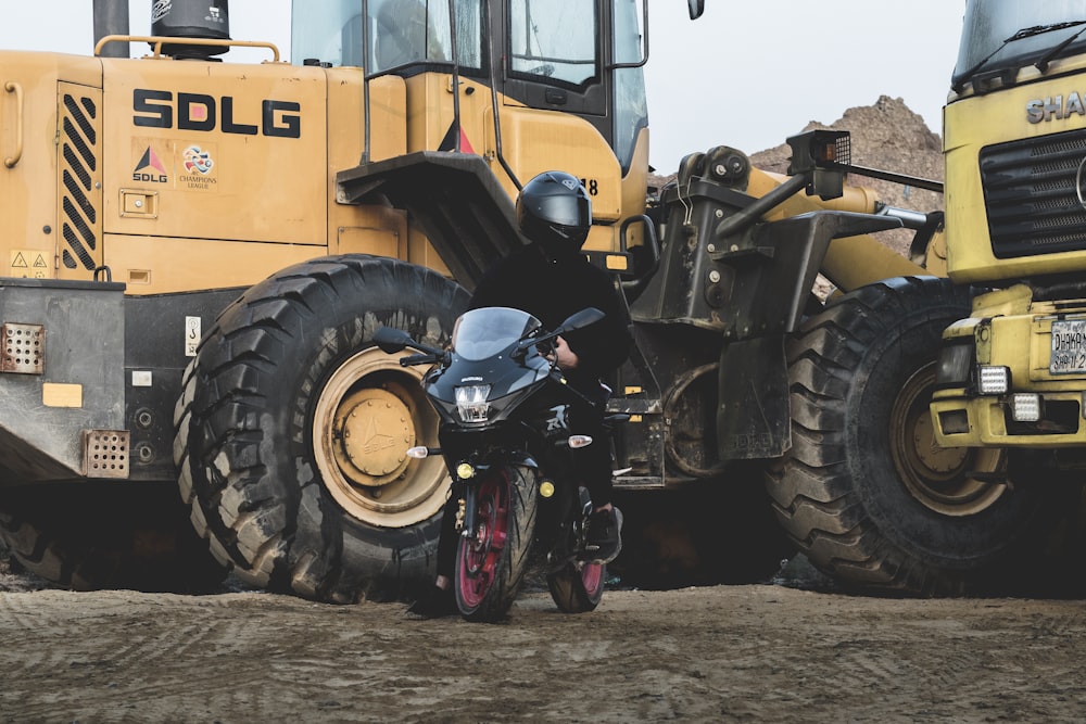 a person on a motorcycle in front of a construction vehicle