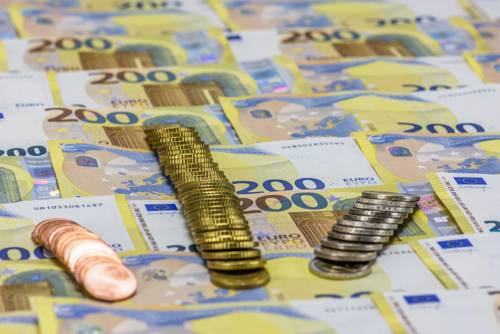 A pile of banknotes beside a stack of coins