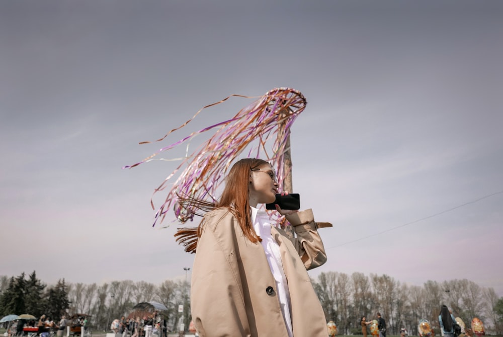 a woman is holding a camera and flying a kite