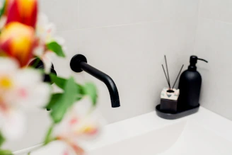 A modern glass pump soap dispenser sitting on a bathroom sink with soft natural light.