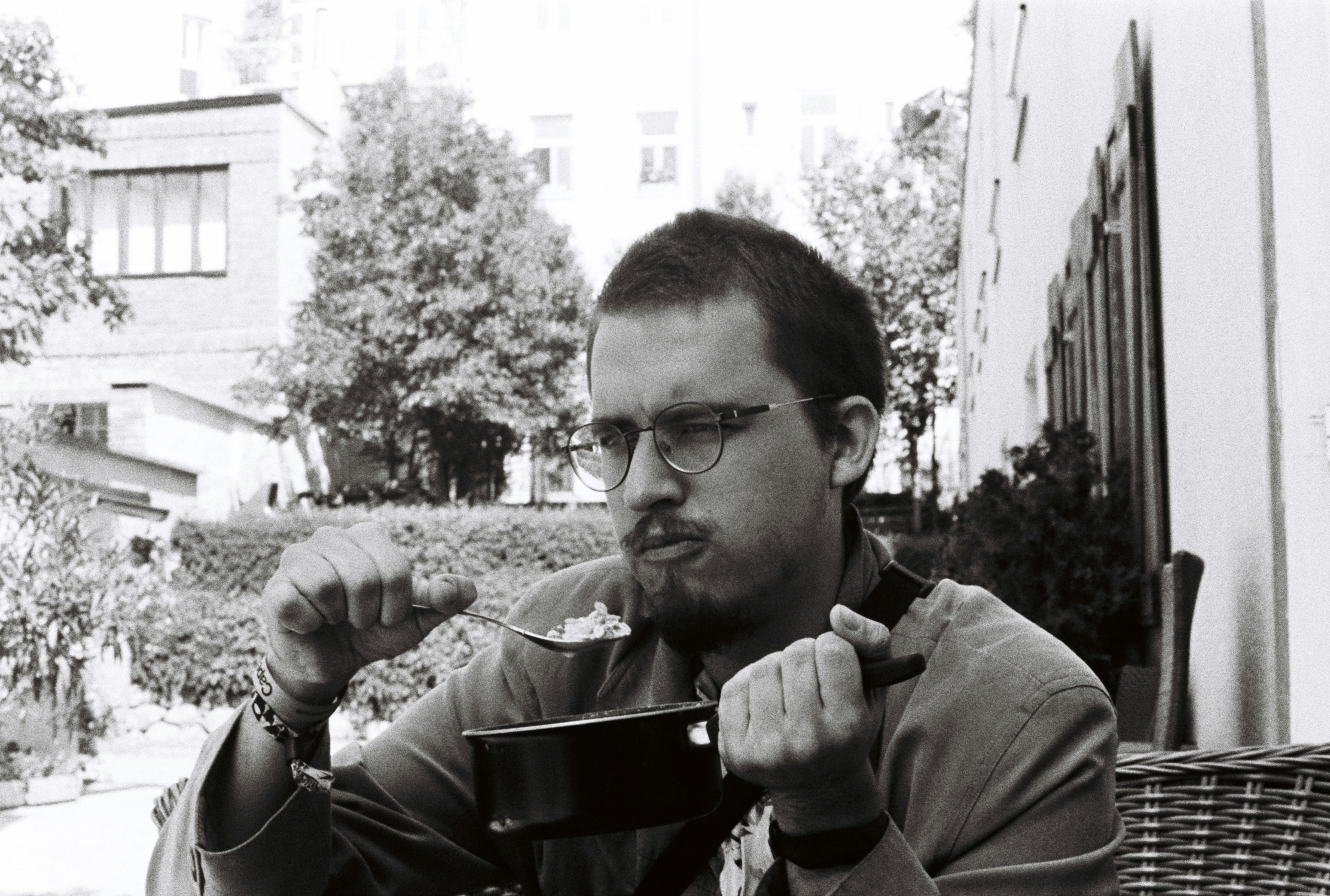 a man sitting at a table eating a bowl of food