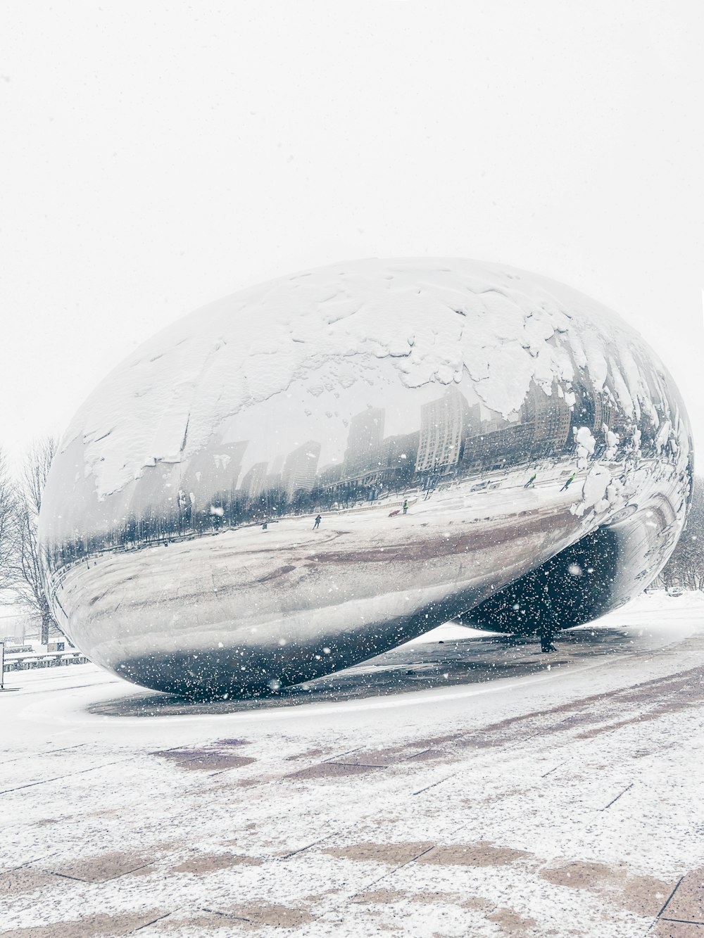 uma grande bola de prata sentada em cima de um chão coberto de neve