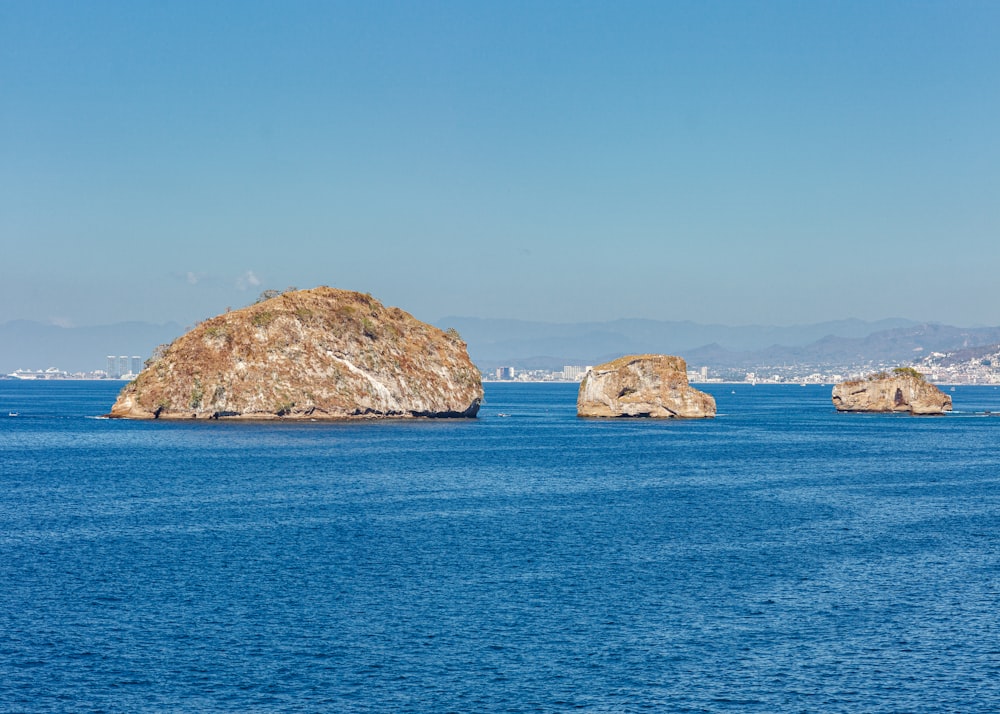 a group of rocks in the middle of a body of water