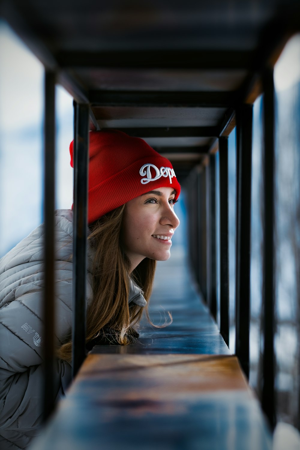 a woman wearing a red hat looking out a window
