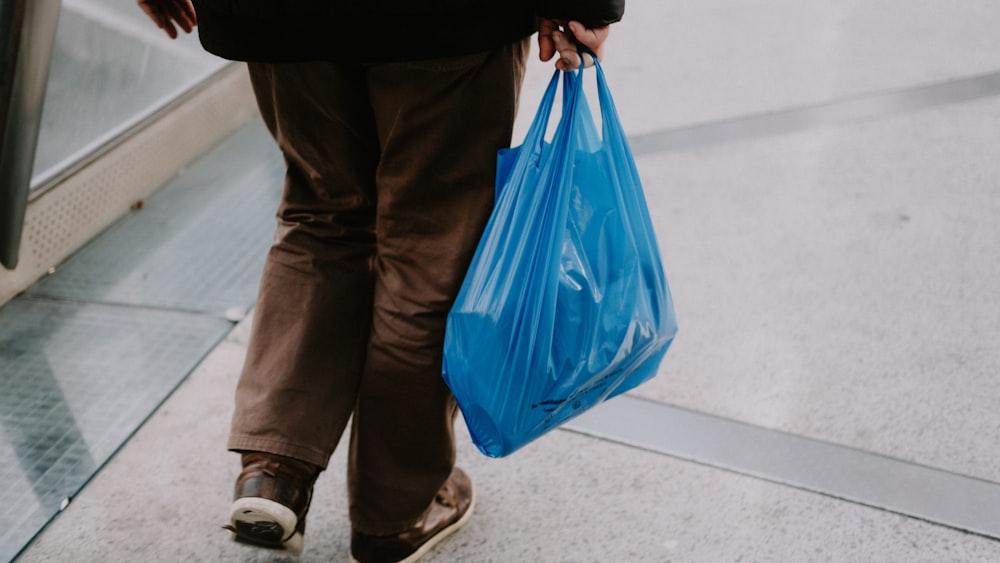 a person with a blue bag walking down an escalator