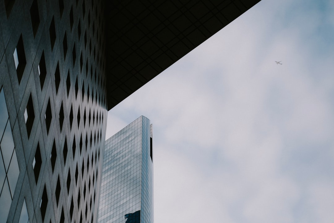 a plane flying in the sky over a building,