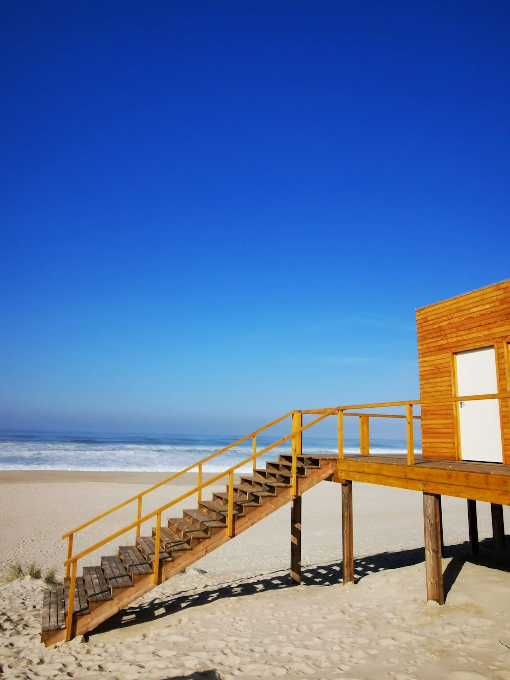 a wooden staircase going up to a beach