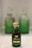 A green glass bottle of Marsoom Fragrance No. 2 with an ornate gold cap is prominently displayed. Behind it, two similar bottles are blurred, creating a sense of depth.