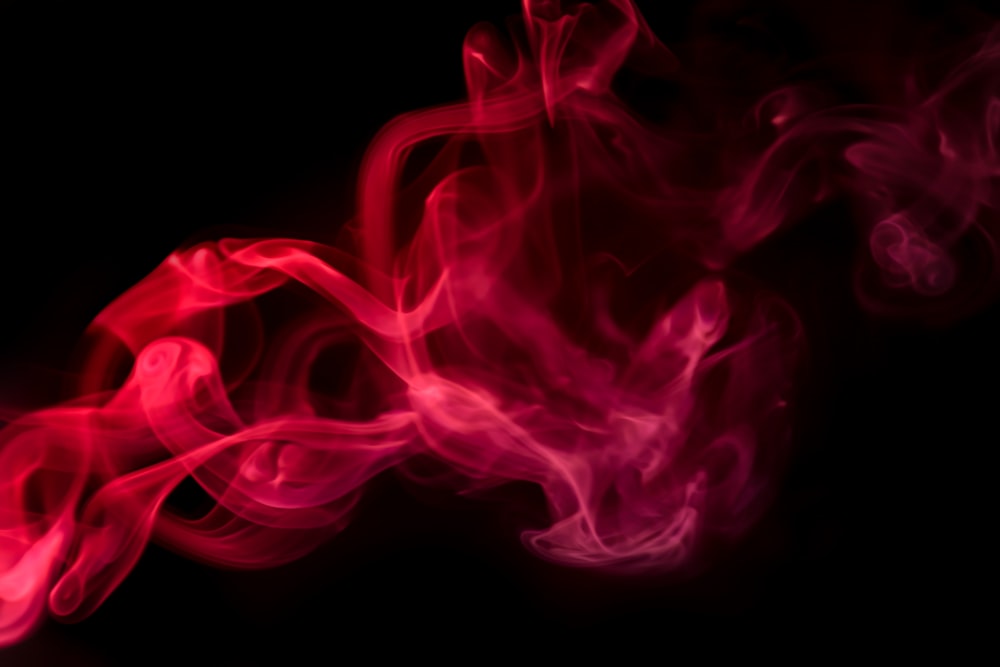 red and pink smoke on a black background