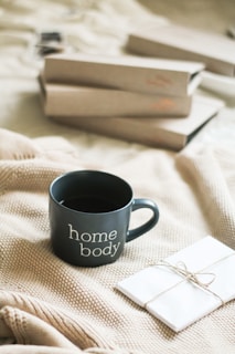 a cup of coffee sitting on top of a bed