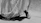 Elegant woman stepping gracefully in black encaaz heels against a minimalist white background.