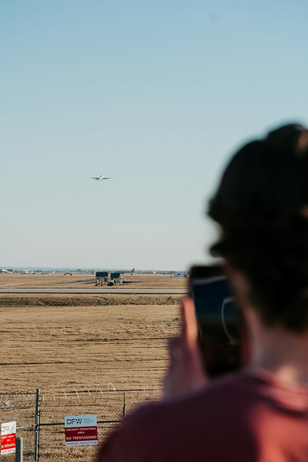 a person taking a picture of an airplane in the sky